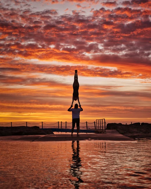 Woman performing a serene yoga pose near water during sunset